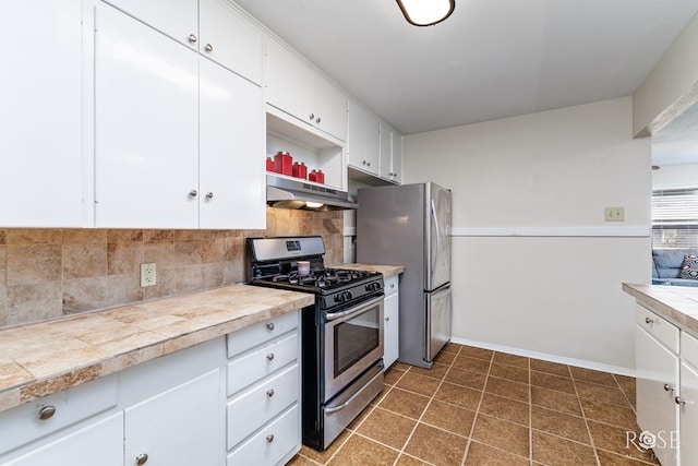 1726 S Park St, San Angelo, TX 76901 - kitchen with white cabinets, under cabinet range hood, backsplash, open shelves, and appliances with stainless steel finishes