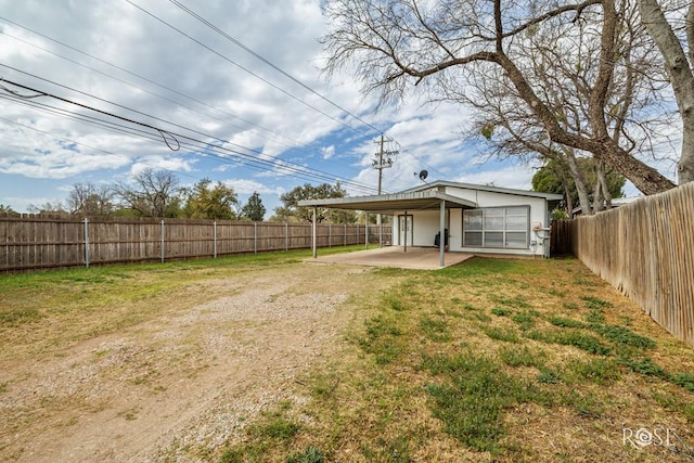 1726 S Park St, San Angelo, TX 76901 - view of yard with a fenced backyard, an attached carport, dirt driveway, and a patio