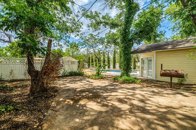 view of yard featuring a fenced in pool and french doors