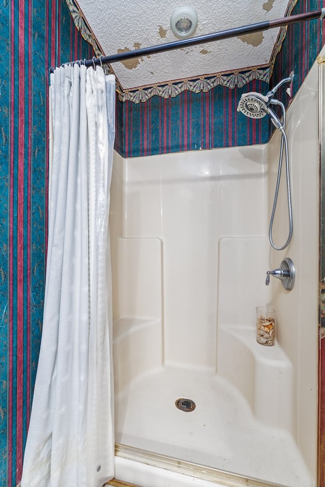 bathroom featuring a textured ceiling and walk in shower