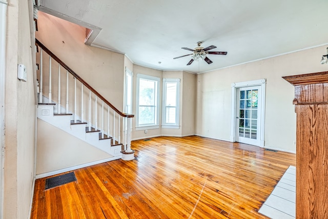 unfurnished living room with ceiling fan, crown molding, light hardwood / wood-style floors, and a healthy amount of sunlight