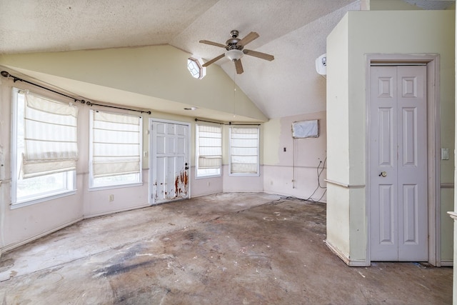 unfurnished room featuring ceiling fan, plenty of natural light, lofted ceiling, and a textured ceiling