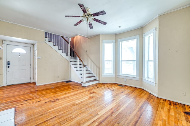 entrance foyer featuring ornamental molding and light wood-type flooring