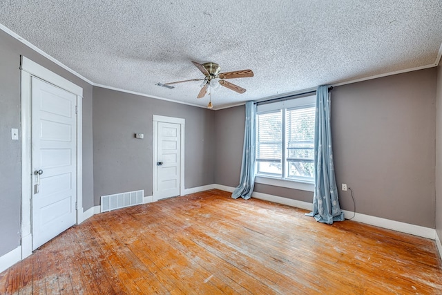 unfurnished room with ceiling fan, ornamental molding, a textured ceiling, and light wood-type flooring