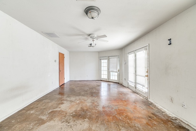 empty room featuring ceiling fan, concrete floors, and a textured ceiling