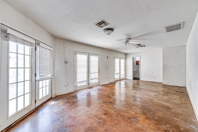 spare room with ceiling fan, concrete floors, and a textured ceiling