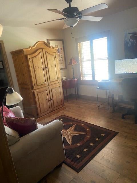 11725 Little Sorrel Trl, San Angelo, TX 76904 - living area with a ceiling fan, light wood finished floors, and baseboards