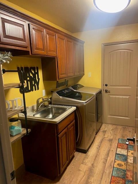 11725 Little Sorrel Trl, San Angelo, TX 76904 - laundry room featuring cabinet space, washer and dryer, and light wood-style flooring