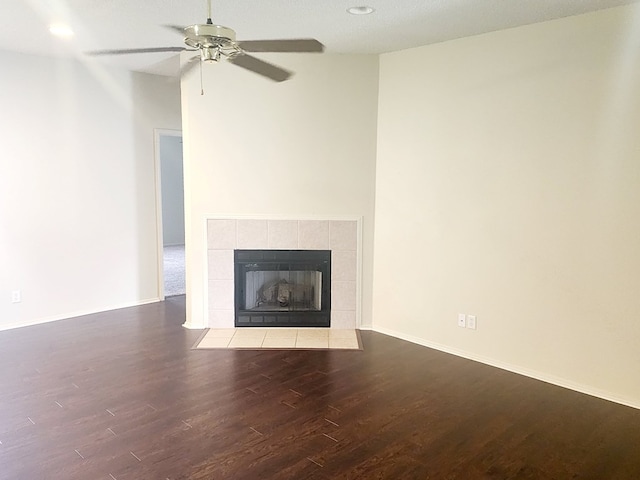 unfurnished living room with a ceiling fan, recessed lighting, baseboards, a tiled fireplace, and wood finished floors