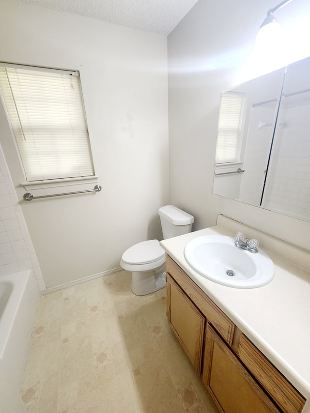 bathroom with toilet, a bathing tub, vanity, and a textured ceiling