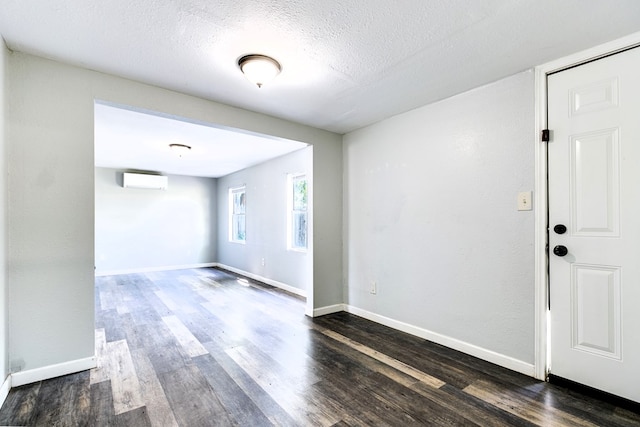 2818 Abilene St, San Angelo, TX 76901 - spare room with a wall mounted air conditioner, wood finished floors, baseboards, and a textured ceiling