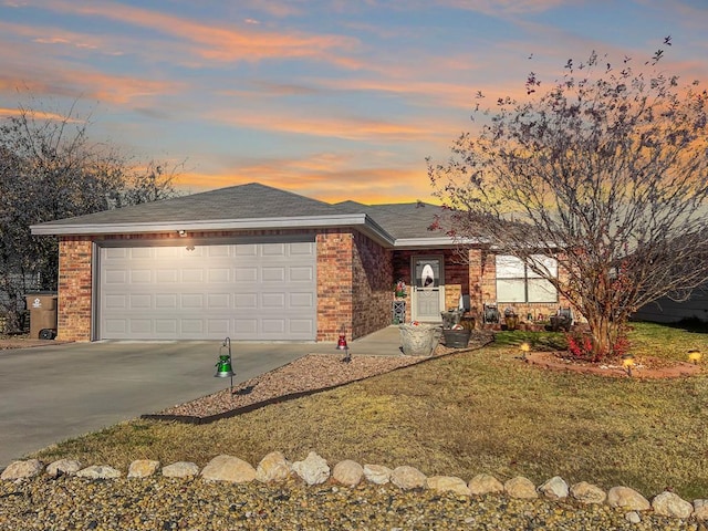 ranch-style home featuring a garage and a yard