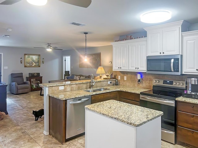 kitchen featuring pendant lighting, sink, white cabinets, and appliances with stainless steel finishes