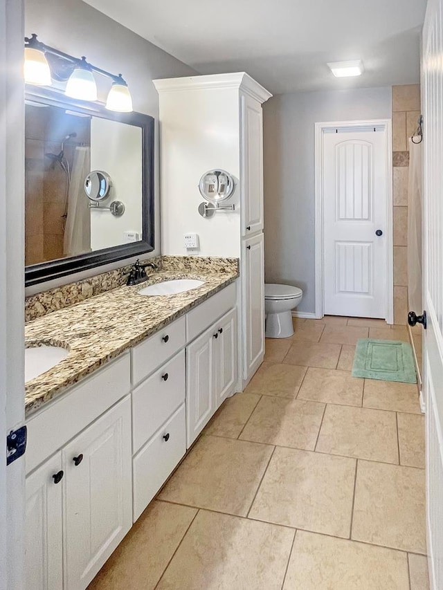 bathroom featuring tile patterned flooring, vanity, and toilet