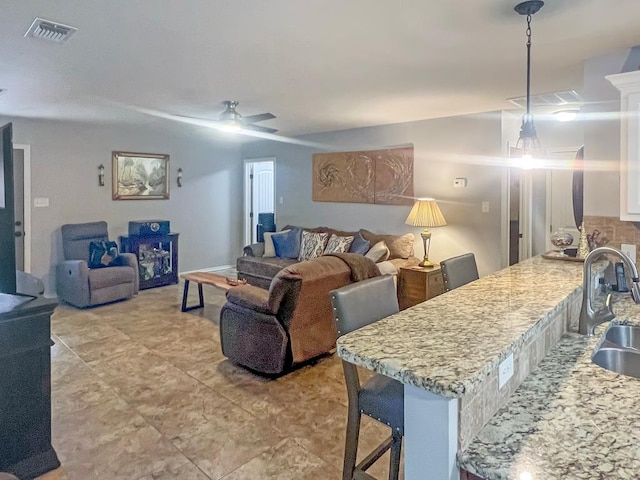 living room with ceiling fan and sink