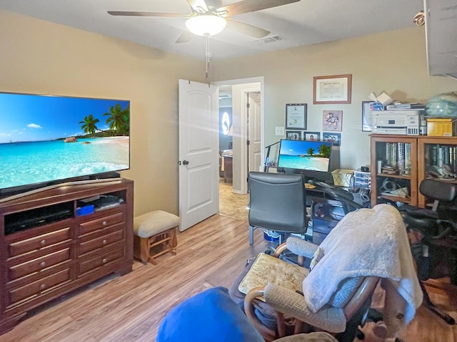 home office with ceiling fan and light hardwood / wood-style floors