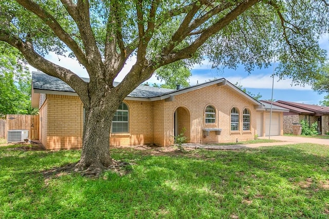 3868 Honeysuckle Ln, San Angelo, TX 76904 - view of front facade featuring a garage, brick siding, central air condition unit, and driveway