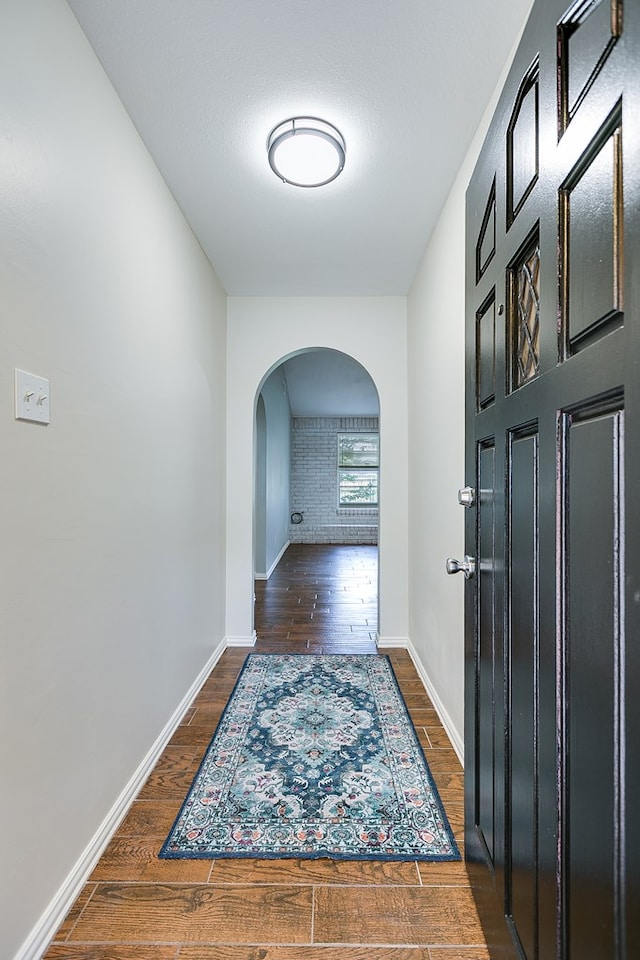 3868 Honeysuckle Ln, San Angelo, TX 76904 - corridor featuring arched walkways, wood finished floors, and baseboards
