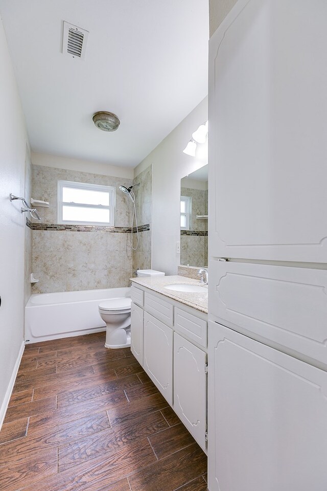 3868 Honeysuckle Ln, San Angelo, TX 76904 - bathroom featuring tub / shower combination, toilet, vanity, and wood finished floors