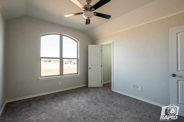 unfurnished bedroom with lofted ceiling, dark carpet, and baseboards