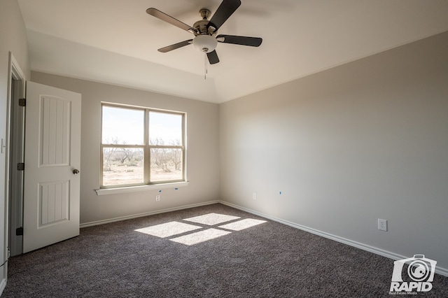 carpeted spare room featuring lofted ceiling, ceiling fan, and baseboards