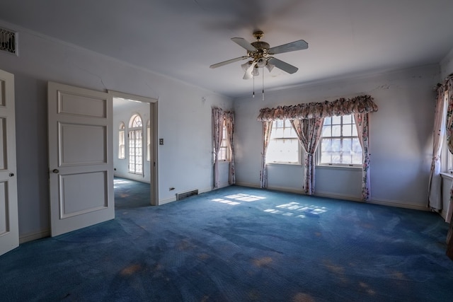 empty room with ceiling fan and dark carpet