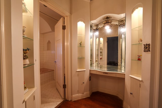 bathroom featuring built in shelves and hardwood / wood-style flooring