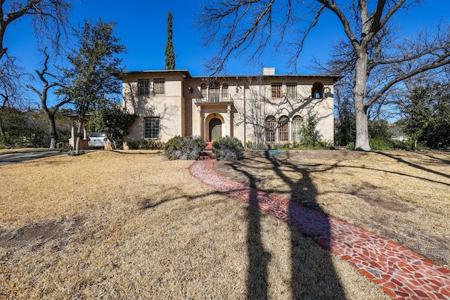 view of front facade featuring a balcony and a front yard