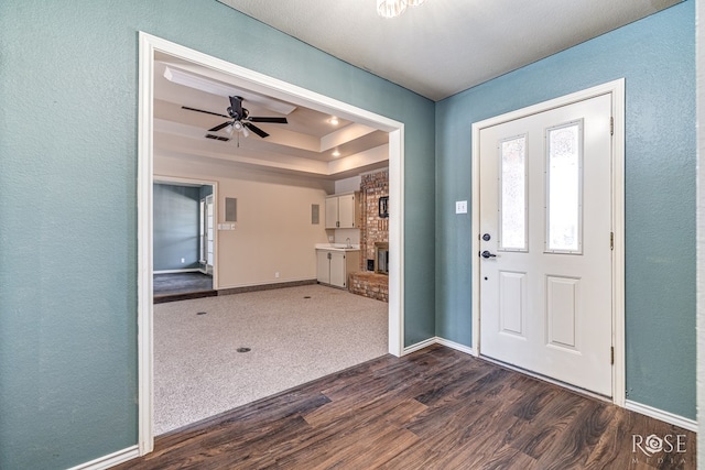 3413 Sequoia Cir, San Angelo, TX 76904 - entryway with dark wood-style flooring, baseboards, a fireplace, a raised ceiling, and a textured wall