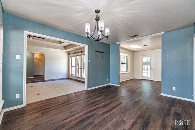 3413 Sequoia Cir, San Angelo, TX 76904 - unfurnished living room featuring healthy amount of natural light, dark wood-type flooring, a chandelier, baseboards, and a textured ceiling