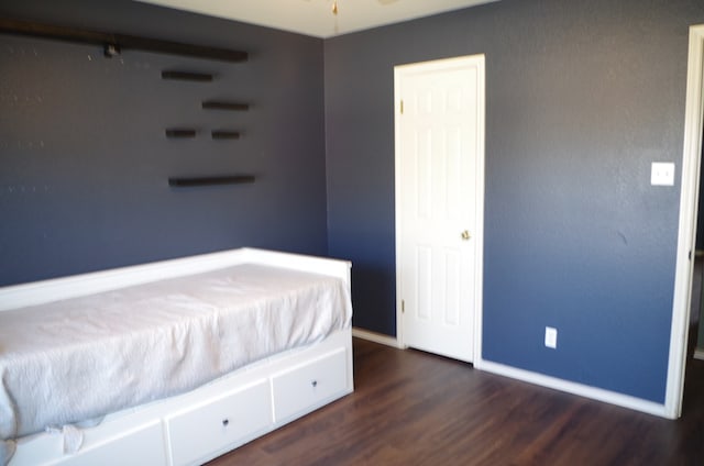 bedroom featuring wood finished floors and baseboards