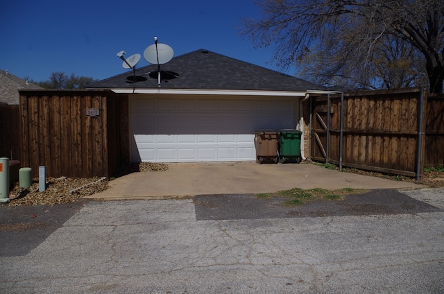 garage with driveway and fence