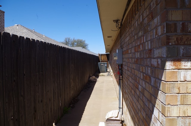 view of property exterior featuring cooling unit, a chimney, and fence