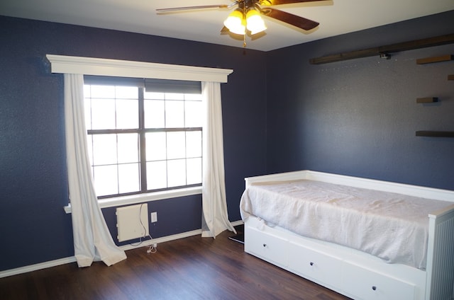 bedroom with a ceiling fan, baseboards, and wood finished floors