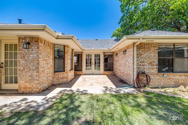 3413 Sequoia Cir, San Angelo, TX 76904 - view of exterior entry featuring french doors, brick siding, a shingled roof, a lawn, and a patio area