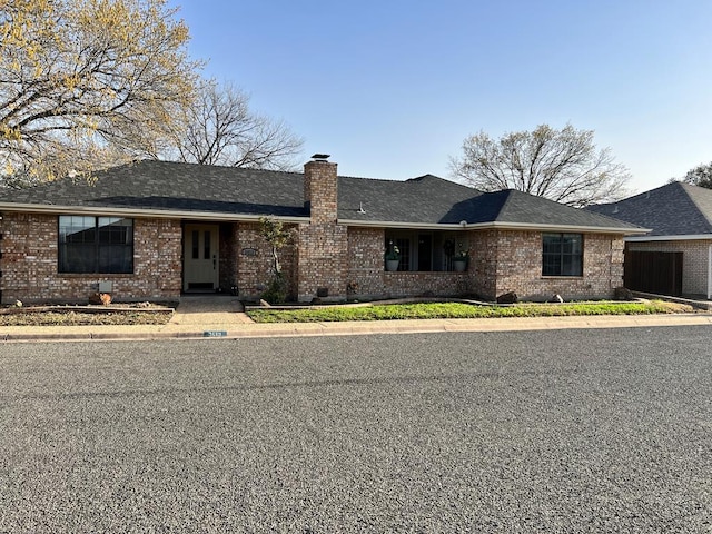 single story home with brick siding and a chimney