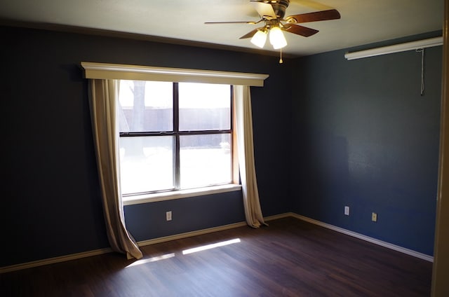 empty room with baseboards, dark wood-type flooring, a healthy amount of sunlight, and ceiling fan