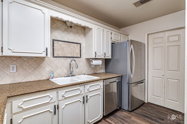 3413 Sequoia Cir, San Angelo, TX 76904 - kitchen featuring stainless steel appliances, a sink, dark wood-type flooring, tasteful backsplash, and white cabinets
