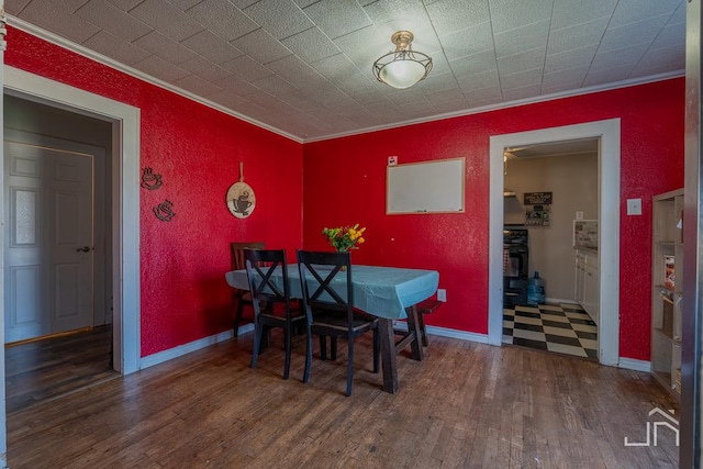 dining space featuring ornamental molding and dark hardwood / wood-style floors