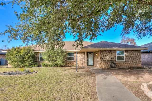 ranch-style home with cooling unit and a front yard