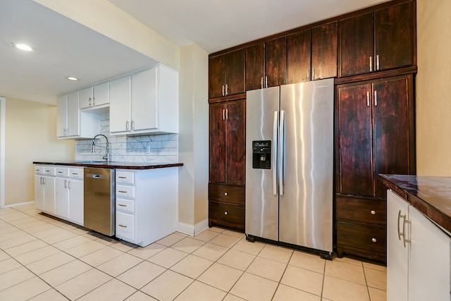 kitchen featuring light tile patterned floors, sink, appliances with stainless steel finishes, backsplash, and dark brown cabinets