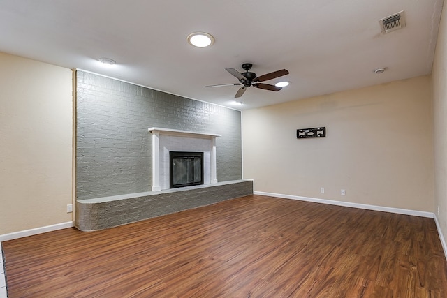 unfurnished living room with ceiling fan, dark wood-type flooring, and a fireplace