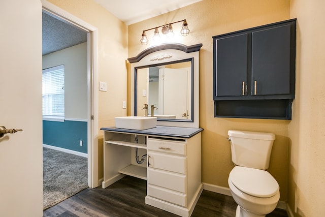 bathroom featuring hardwood / wood-style flooring, vanity, a textured ceiling, and toilet