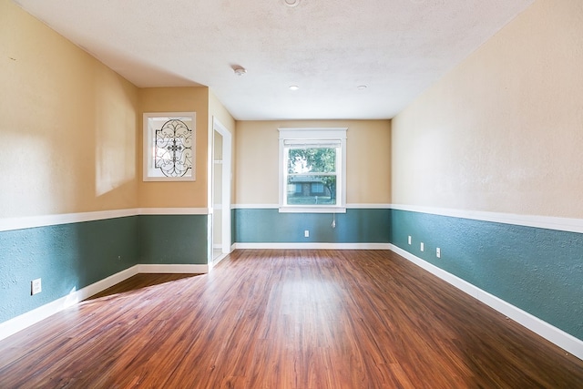 spare room featuring hardwood / wood-style flooring and a textured ceiling