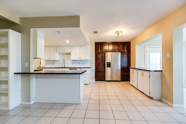 kitchen featuring white cabinetry, stainless steel refrigerator with ice dispenser, tasteful backsplash, dark brown cabinetry, and kitchen peninsula