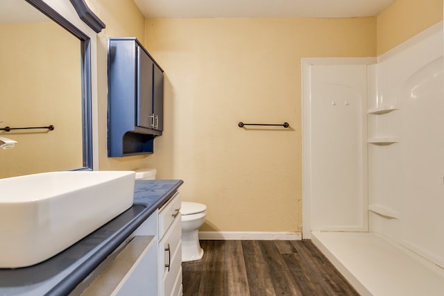 bathroom with vanity, hardwood / wood-style floors, walk in shower, and toilet