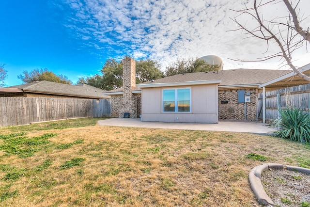 rear view of property featuring a yard and a patio area