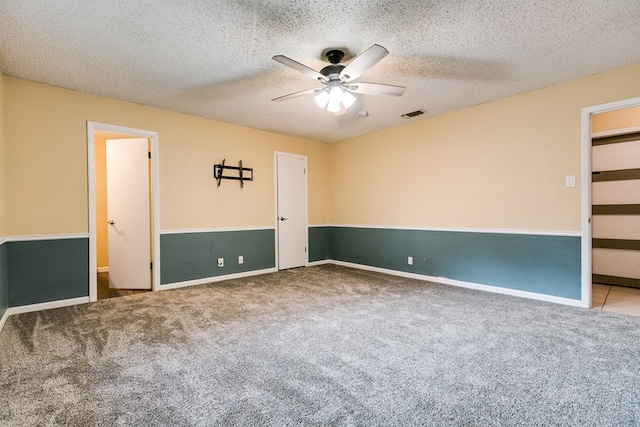 unfurnished bedroom with light carpet, a textured ceiling, and ceiling fan