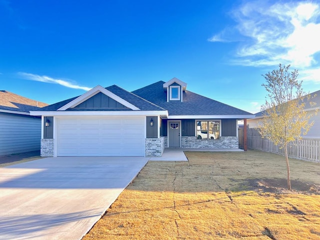 view of front facade featuring fence, board and batten siding, concrete driveway, an attached garage, and brick siding