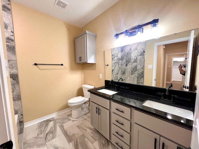 bathroom with toilet, visible vents, marble finish floor, and a sink